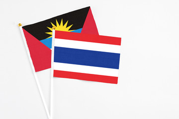 Thailand and Antigua and Barbuda stick flags on white background. High quality fabric, miniature national flag. Peaceful global concept.White floor for copy space.