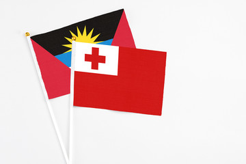 Tonga and Antigua and Barbuda stick flags on white background. High quality fabric, miniature national flag. Peaceful global concept.White floor for copy space.