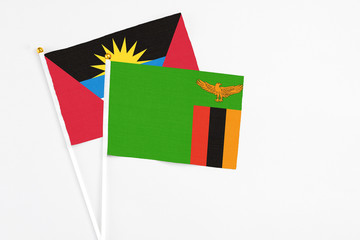 Zambia and Antigua and Barbuda stick flags on white background. High quality fabric, miniature national flag. Peaceful global concept.White floor for copy space.