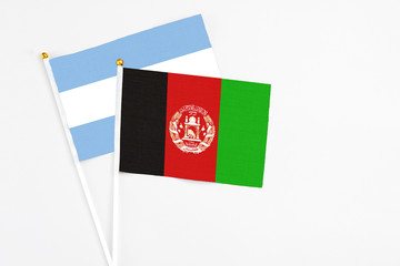 Afghanistan and Argentina stick flags on white background. High quality fabric, miniature national...