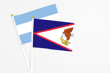 American Samoa and Argentina stick flags on white background. High quality fabric, miniature national flag. Peaceful global concept.White floor for copy space.