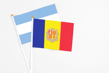 Andorra and Argentina stick flags on white background. High quality fabric, miniature national flag. Peaceful global concept.White floor for copy space.