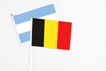 Belgium and Argentina stick flags on white background. High quality fabric, miniature national flag. Peaceful global concept.White floor for copy space.