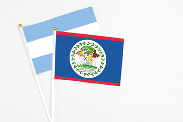 Belize and Argentina stick flags on white background. High quality fabric, miniature national flag. Peaceful global concept.White floor for copy space.