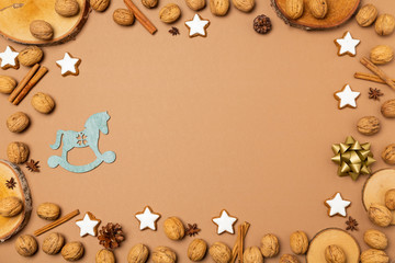 Weihnachtlicher, brauner Hintergrund mit Walnüssen, Zimtsternen und Baumscheiben, mit Textfreiraum 