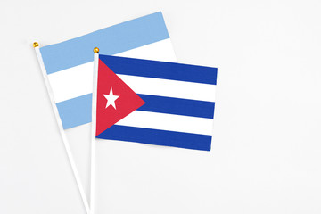 Cuba and Argentina stick flags on white background. High quality fabric, miniature national flag. Peaceful global concept.White floor for copy space.