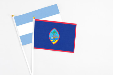 Guam and Argentina stick flags on white background. High quality fabric, miniature national flag. Peaceful global concept.White floor for copy space.