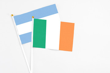 Ireland and Argentina stick flags on white background. High quality fabric, miniature national flag. Peaceful global concept.White floor for copy space.