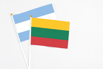 Lithuania and Argentina stick flags on white background. High quality fabric, miniature national flag. Peaceful global concept.White floor for copy space.