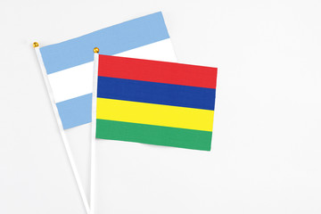 Mauritius and Argentina stick flags on white background. High quality fabric, miniature national flag. Peaceful global concept.White floor for copy space.