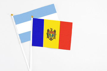 Moldova and Argentina stick flags on white background. High quality fabric, miniature national flag. Peaceful global concept.White floor for copy space.
