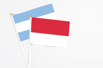 Monaco and Argentina stick flags on white background. High quality fabric, miniature national flag. Peaceful global concept.White floor for copy space.