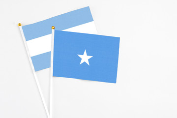 Somalia and Argentina stick flags on white background. High quality fabric, miniature national flag. Peaceful global concept.White floor for copy space.