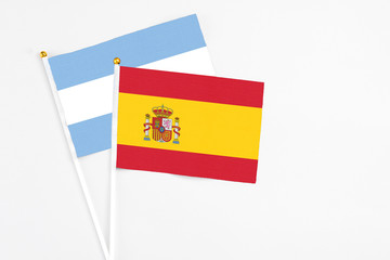 Spain and Argentina stick flags on white background. High quality fabric, miniature national flag. Peaceful global concept.White floor for copy space.