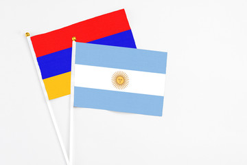 Argentina and Armenia stick flags on white background. High quality fabric, miniature national flag. Peaceful global concept.White floor for copy space.