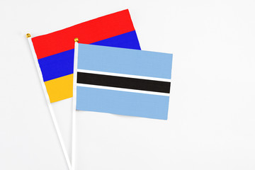 Botswana and Armenia stick flags on white background. High quality fabric, miniature national flag. Peaceful global concept.White floor for copy space.