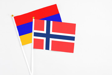 Obraz premium Bouvet Islands and Armenia stick flags on white background. High quality fabric, miniature national flag. Peaceful global concept.White floor for copy space.