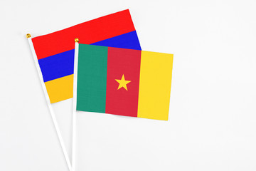 Cameroon and Armenia stick flags on white background. High quality fabric, miniature national flag. Peaceful global concept.White floor for copy space.
