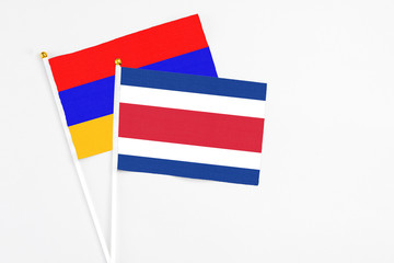 Costa Rica and Armenia stick flags on white background. High quality fabric, miniature national flag. Peaceful global concept.White floor for copy space.
