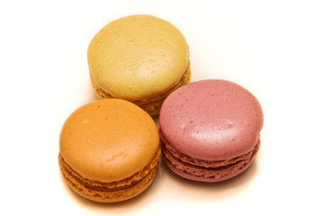 An assortment of three french almond macaron cookies of different flavors and colors.