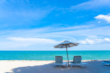 Beautiful umbrella and chair around beach sea ocean with blue sky for travel