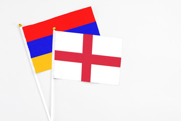 England and Armenia stick flags on white background. High quality fabric, miniature national flag. Peaceful global concept.White floor for copy space.