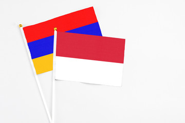 Indonesia and Armenia stick flags on white background. High quality fabric, miniature national flag. Peaceful global concept.White floor for copy space.