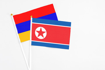 North Korea and Armenia stick flags on white background. High quality fabric, miniature national flag. Peaceful global concept.White floor for copy space.