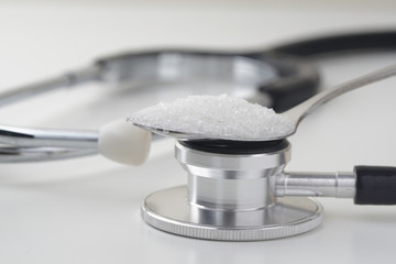 Sugar in a tea spoon on the stethoscope