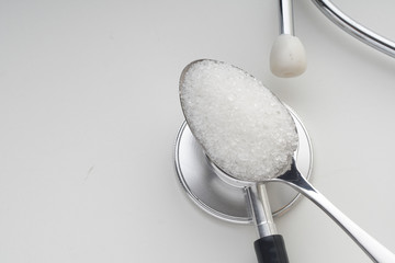 Sugar in a tea spoon on the stethoscope