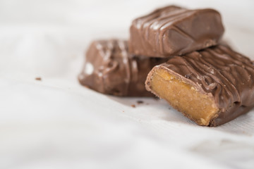 CHOCOLATE BARS WITH TOFFEE CARAMEL ON WHITE NAPKIN (COPY SPACE)