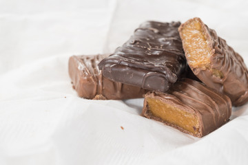 CHOCOLATE BARS WITH TOFFEE CARAMEL ON WHITE NAPKIN (COPY SPACE)