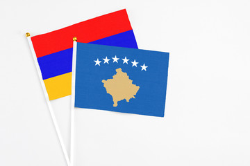 Kosovo and Armenia stick flags on white background. High quality fabric, miniature national flag. Peaceful global concept.White floor for copy space.