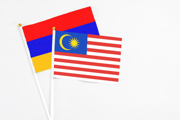Malaysia and Armenia stick flags on white background. High quality fabric, miniature national flag. Peaceful global concept.White floor for copy space.