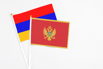 Montenegro and Armenia stick flags on white background. High quality fabric, miniature national flag. Peaceful global concept.White floor for copy space.