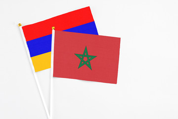 Morocco and Armenia stick flags on white background. High quality fabric, miniature national flag. Peaceful global concept.White floor for copy space.