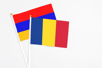 Romania and Armenia stick flags on white background. High quality fabric, miniature national flag. Peaceful global concept.White floor for copy space.