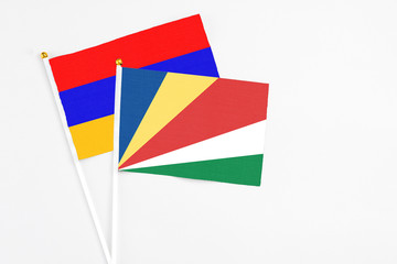 Seychelles and Armenia stick flags on white background. High quality fabric, miniature national flag. Peaceful global concept.White floor for copy space.