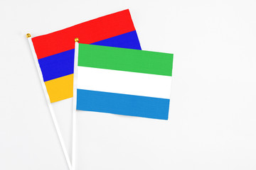 Sierra Leone and Armenia stick flags on white background. High quality fabric, miniature national flag. Peaceful global concept.White floor for copy space.