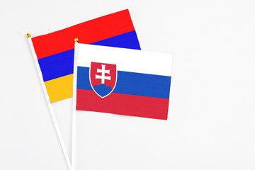 Slovakia and Armenia stick flags on white background. High quality fabric, miniature national flag. Peaceful global concept.White floor for copy space.