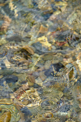 Clear water ripples over colorful stone.