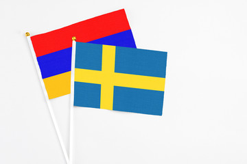 Sweden and Armenia stick flags on white background. High quality fabric, miniature national flag. Peaceful global concept.White floor for copy space.