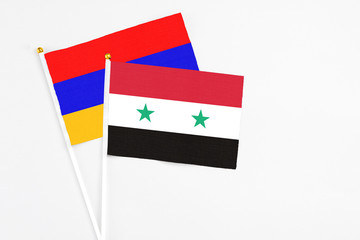 Syria and Armenia stick flags on white background. High quality fabric, miniature national flag. Peaceful global concept.White floor for copy space.