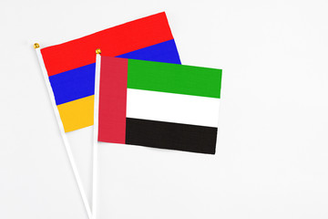 United Arab Emirates and Armenia stick flags on white background. High quality fabric, miniature national flag. Peaceful global concept.White floor for copy space.