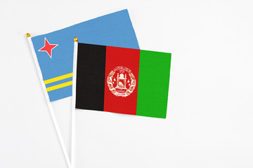 Afghanistan and Aruba stick flags on white background. High quality fabric, miniature national flag. Peaceful global concept.White floor for copy space.