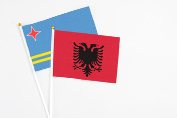 Obraz premium Albania and Aruba stick flags on white background. High quality fabric, miniature national flag. Peaceful global concept.White floor for copy space.