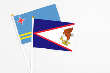 American Samoa and Aruba stick flags on white background. High quality fabric, miniature national flag. Peaceful global concept.White floor for copy space.