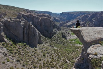 A man sitting on the edge of the cliff in Atuel Canyon, Mendoza, Argentina
