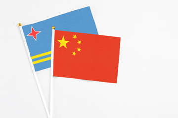 China and Aruba stick flags on white background. High quality fabric, miniature national flag. Peaceful global concept.White floor for copy space.
