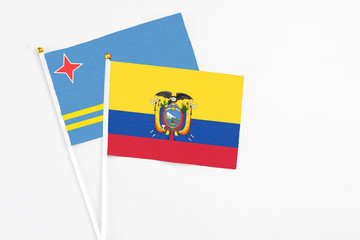 Ecuador and Aruba stick flags on white background. High quality fabric, miniature national flag. Peaceful global concept.White floor for copy space.